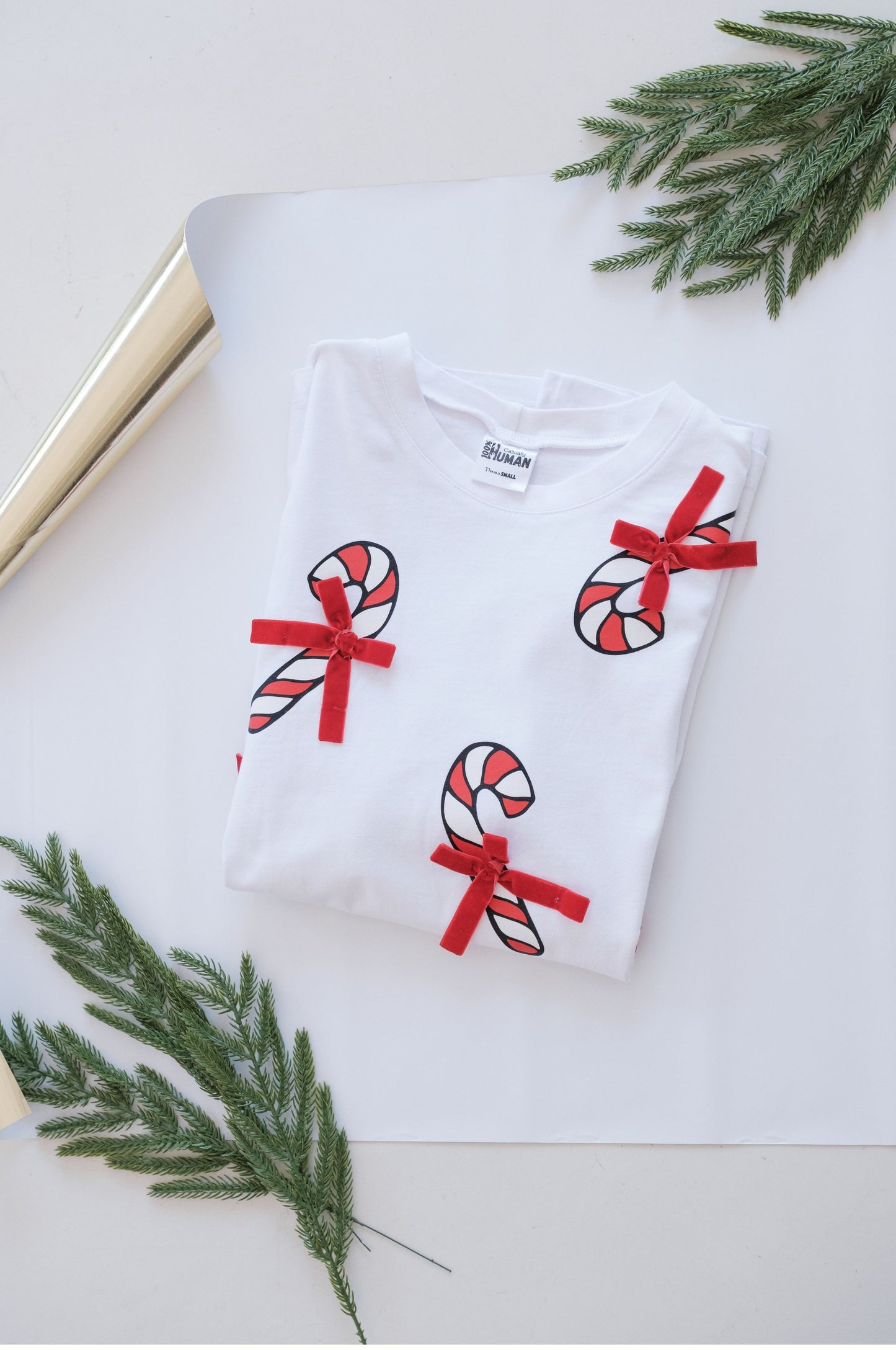 White Christmas t-shirt with candy cane design and red bows folded flat festive outfit South Africa