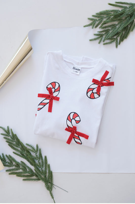 White Christmas t-shirt with candy cane design and red bows folded flat festive outfit South Africa