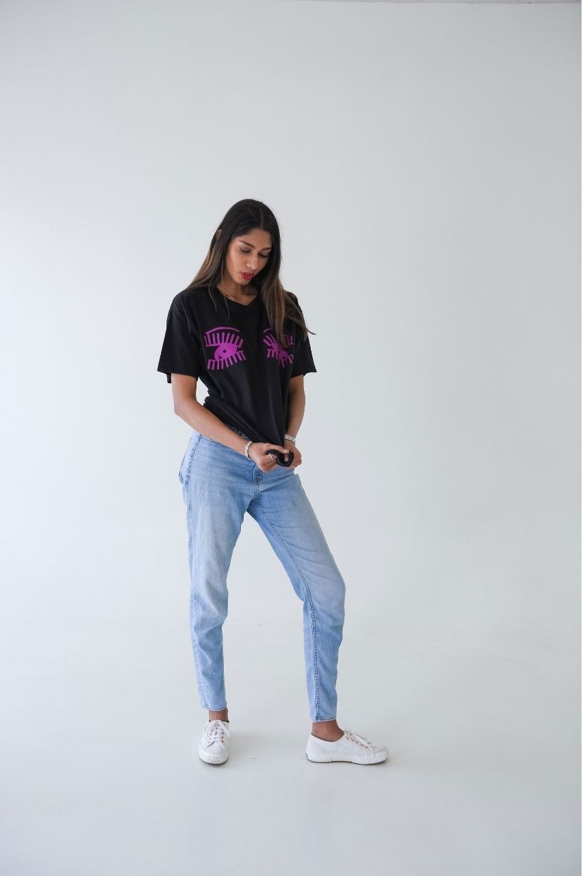 Black t-shirt with pink eye design styled with jeans casual streetwear outfit
