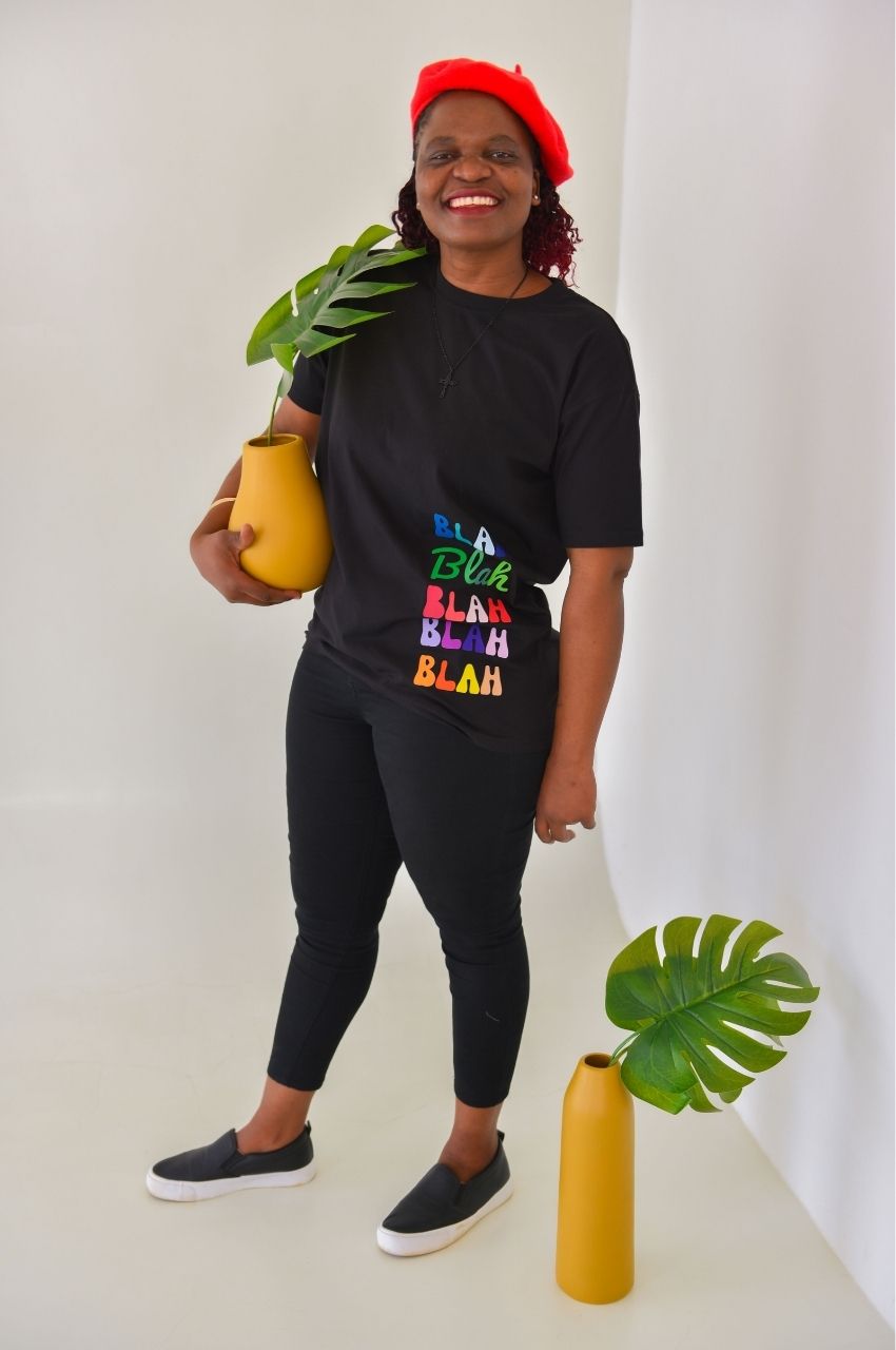 Woman styling black Blah graphic t-shirt with jeans holding plant modern casual outfit South Africa