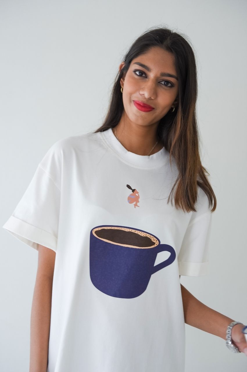 Woman wearing white t-shirt with illustration of lady diving into coffee cup casual fashion South Africa
