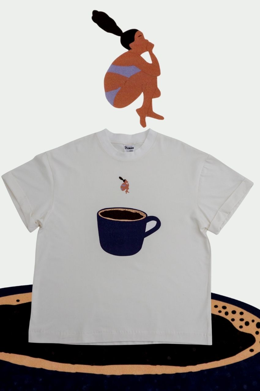 White t-shirt with large coffee cup and woman diving into coffee graphic minimalist design