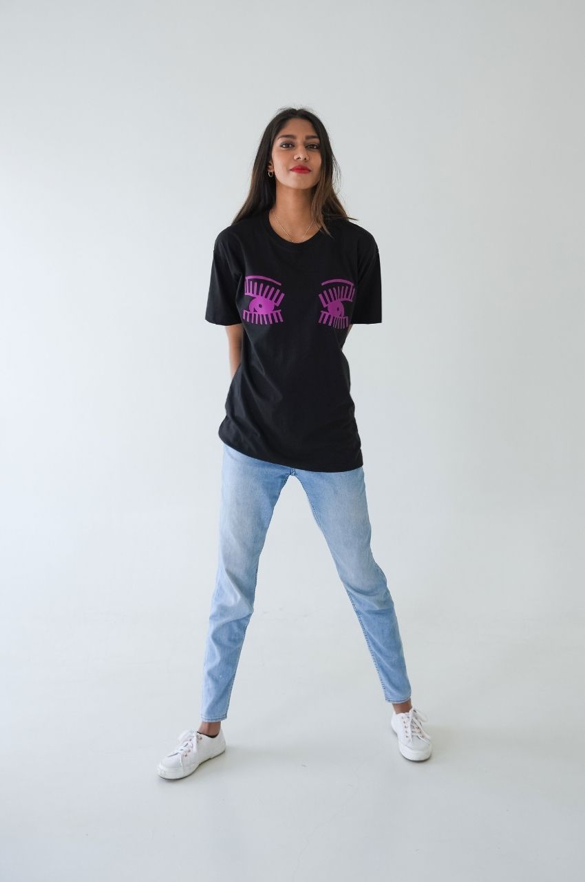 Woman wearing oversized black t-shirt with pink eye print streetwear fashion look