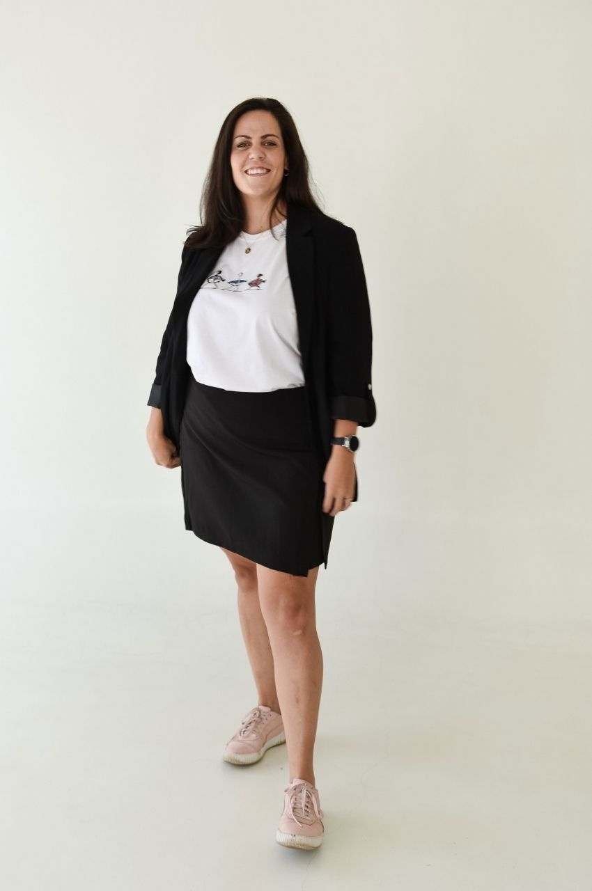Full outfit styling of white fish graphic t-shirt with skirt and sneakers casual chic look
