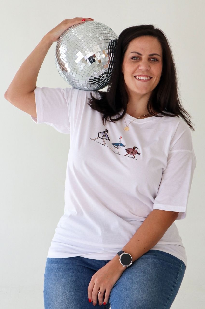 Woman holding disco ball wearing quirky fish illustration t-shirt fun fashion South Africa
