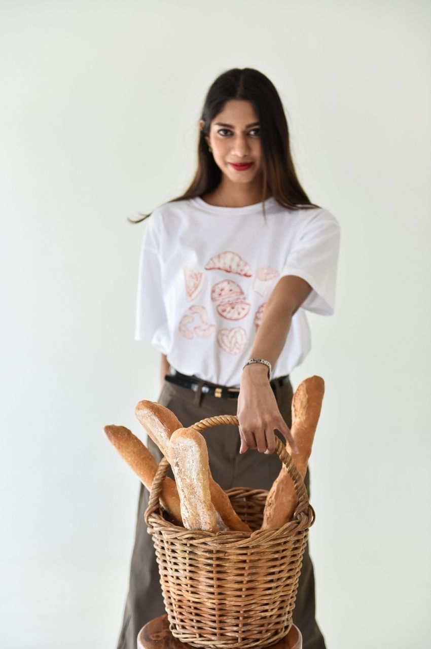 Woman holding basket of bread wearing food themed graphic t-shirt lifestyle fashion South Africa