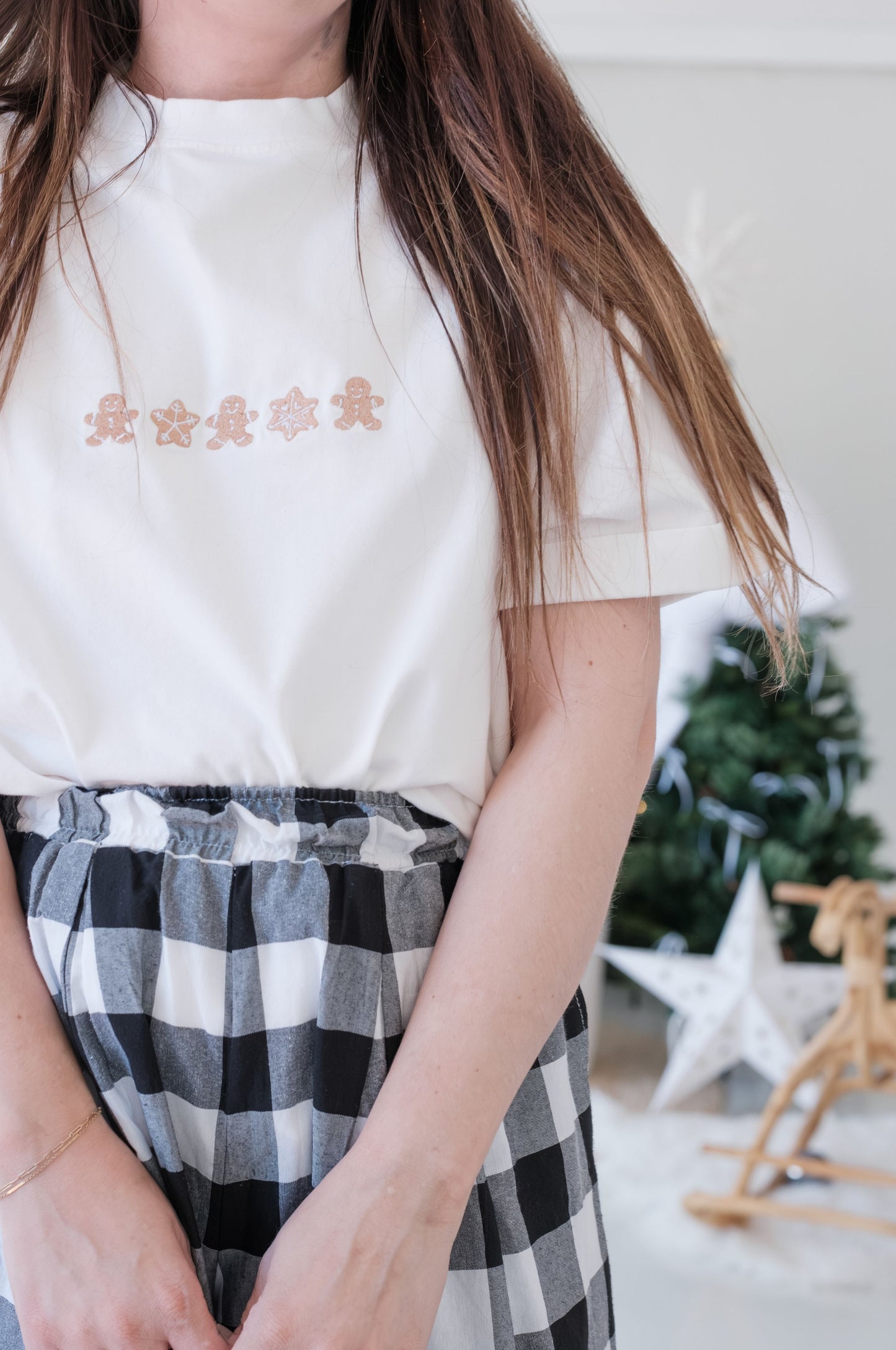 Close-up of white Christmas t-shirt with gingerbread and snowflake embroidered design, minimal festive clothing South Africa