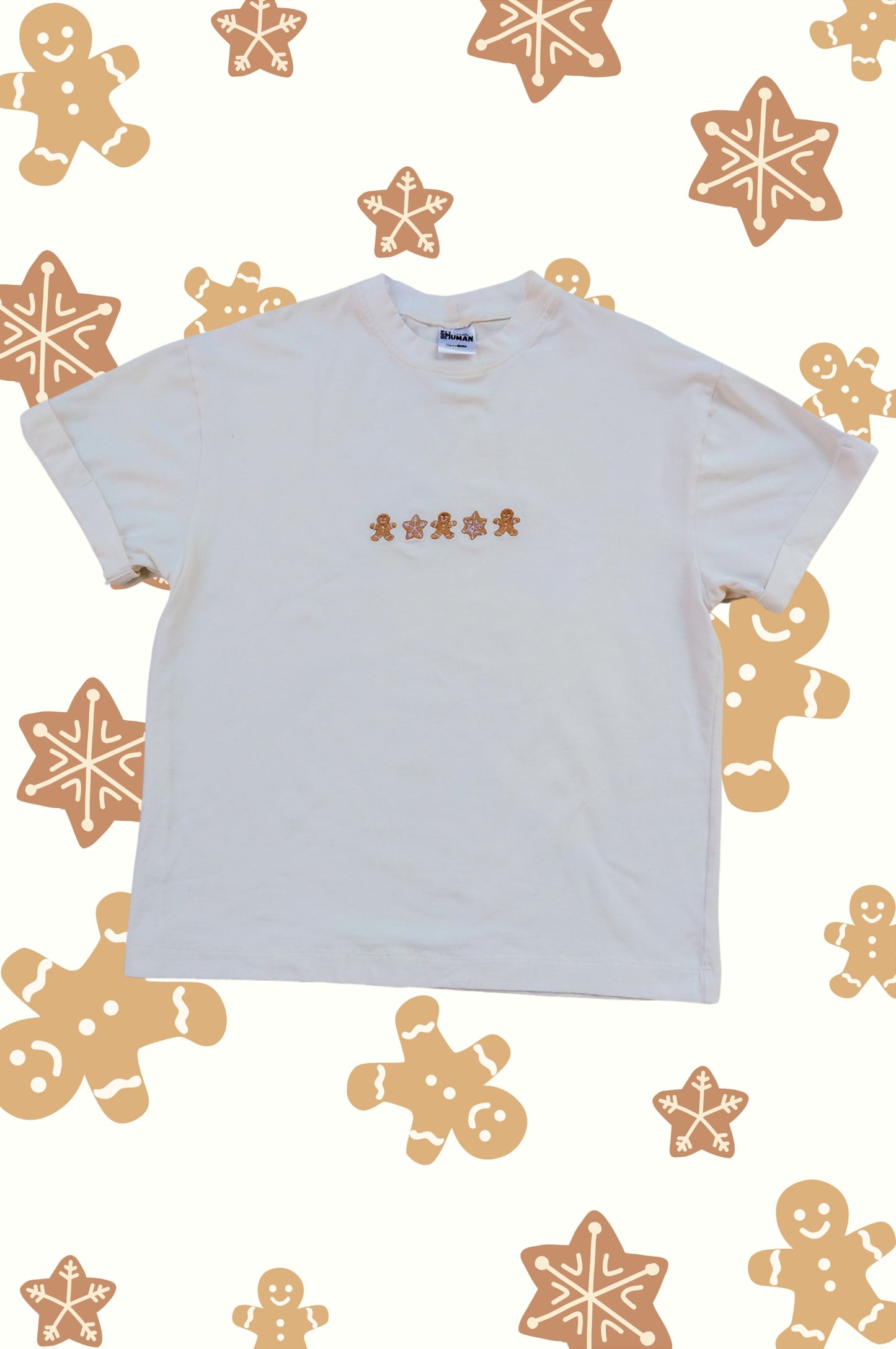Minimalist Christmas t-shirt with gingerbread and snowflake embroidery on festive patterned background South Africa