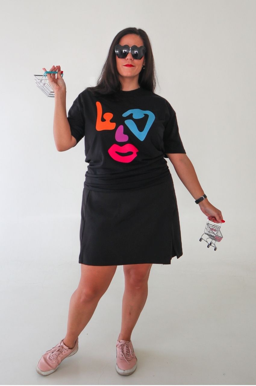 Black t-shirt with colorful modern art face design styled with casual skirt and sneakers South Africa