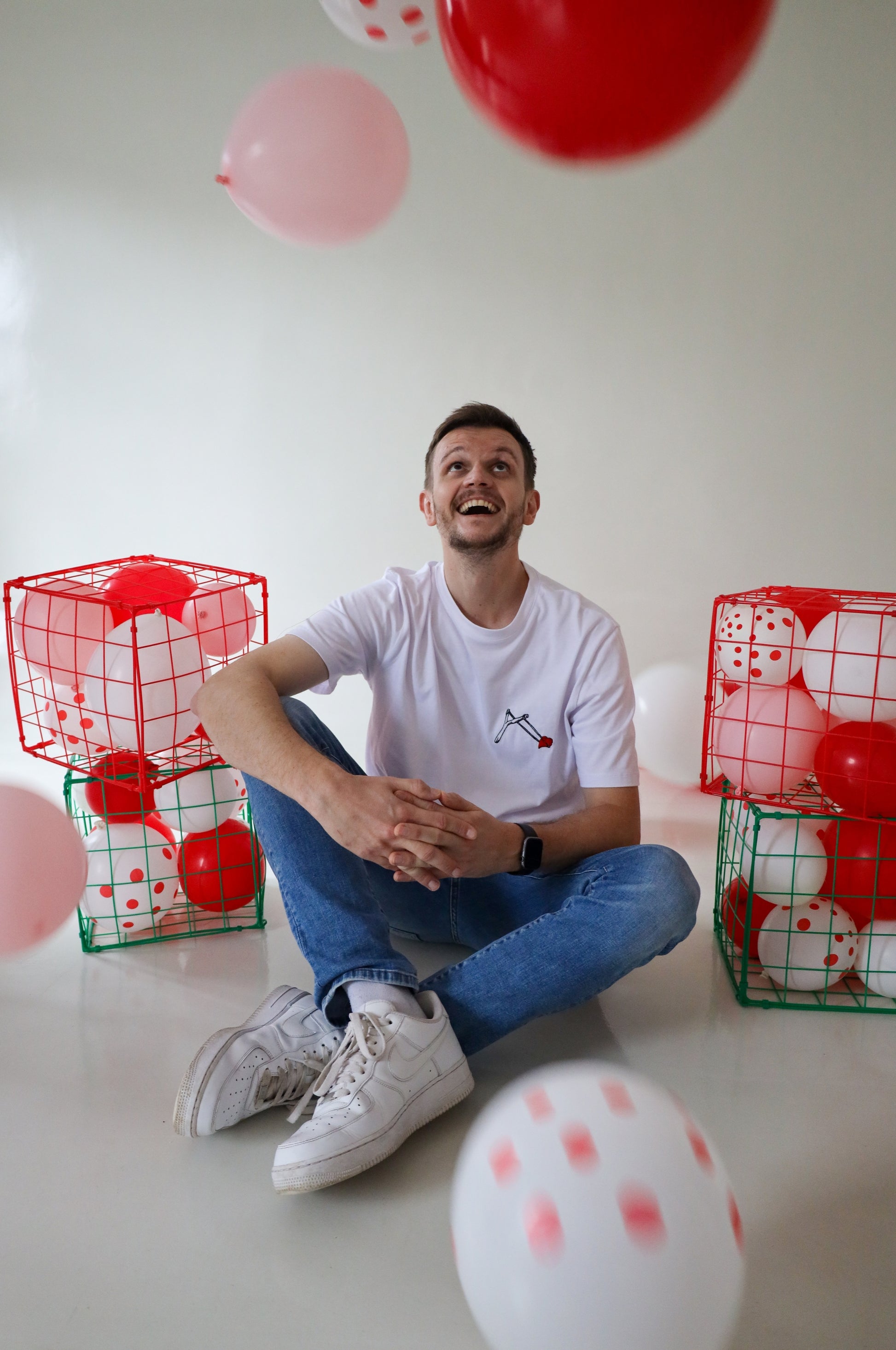 Man wearing white graphic t-shirt with embroidered heart design, quirky 100% cotton tee in playful setting, South Africa