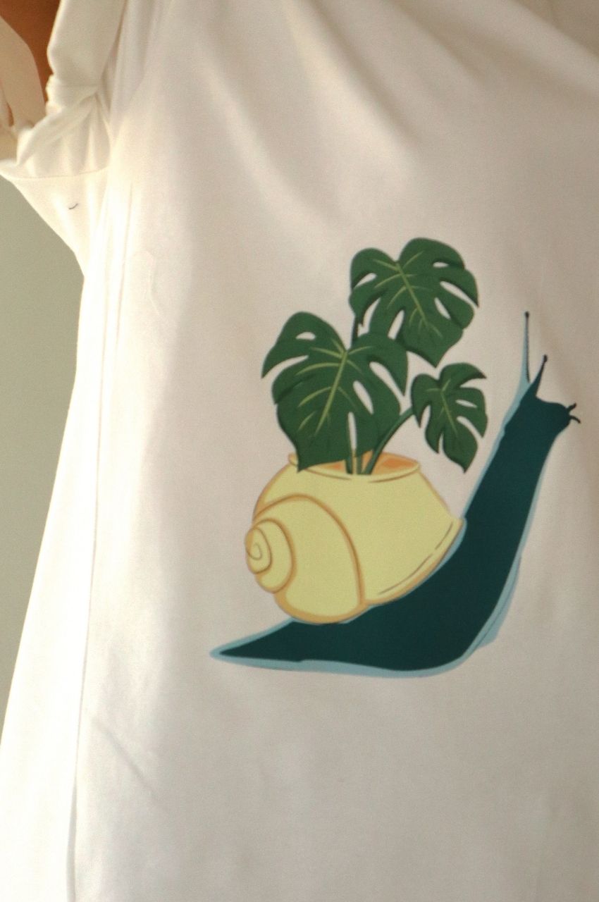 Close up of white t-shirt with snail and monstera leaf illustration minimalist nature design South Africa