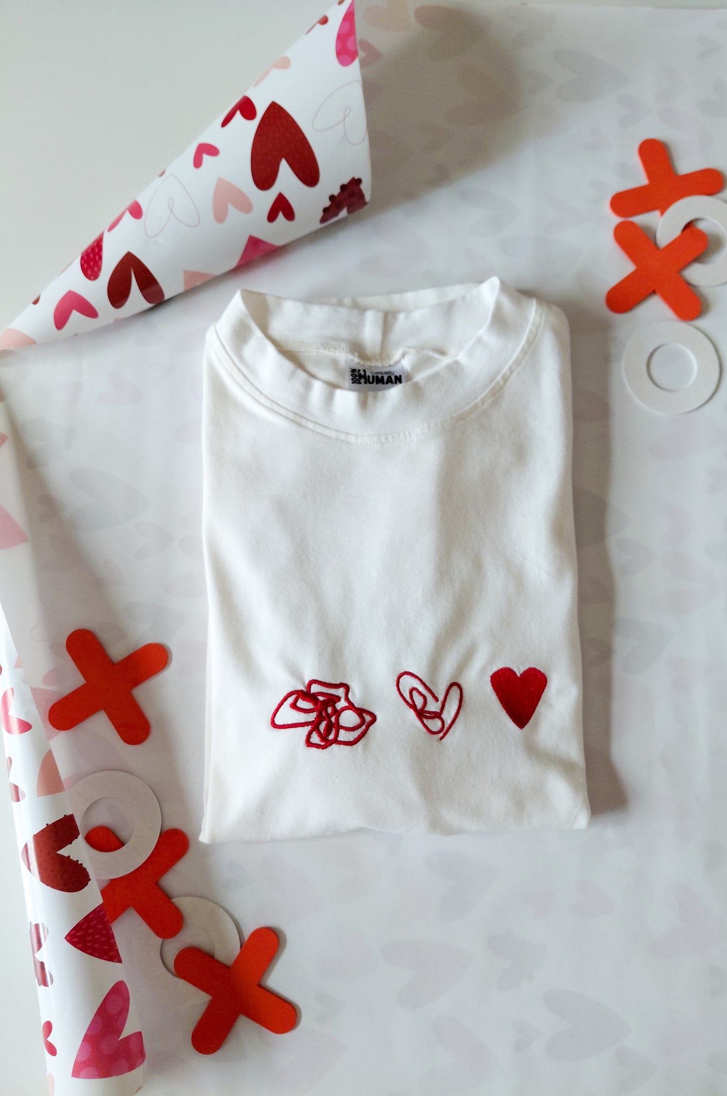 White graphic t-shirt with red heart embroidery, 100% cotton quirky tee flat lay with gift wrap South Africa