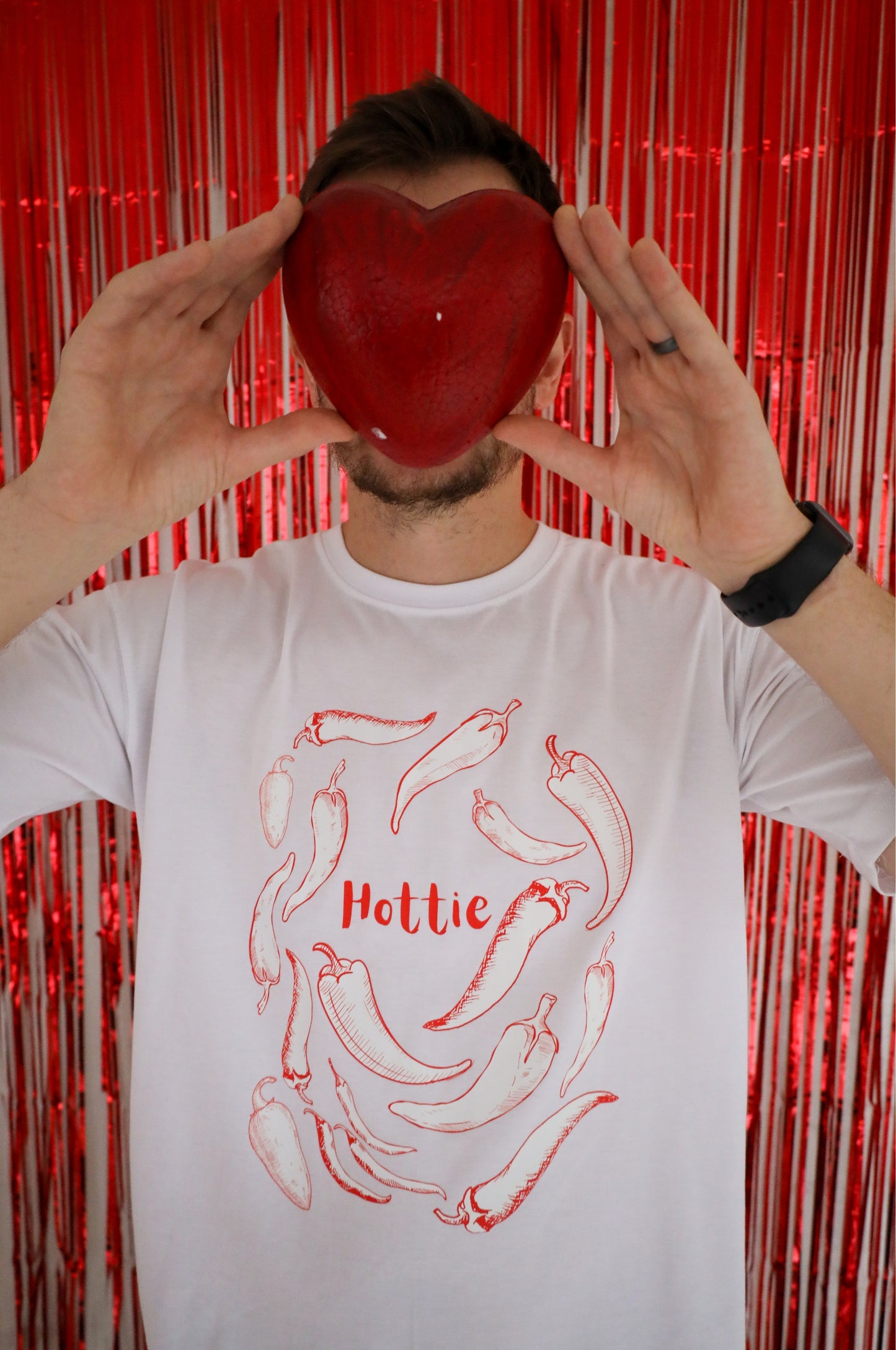 White graphic t-shirt with chilli design and Hottie text, funny cotton tee in bold red lifestyle setting South Africa