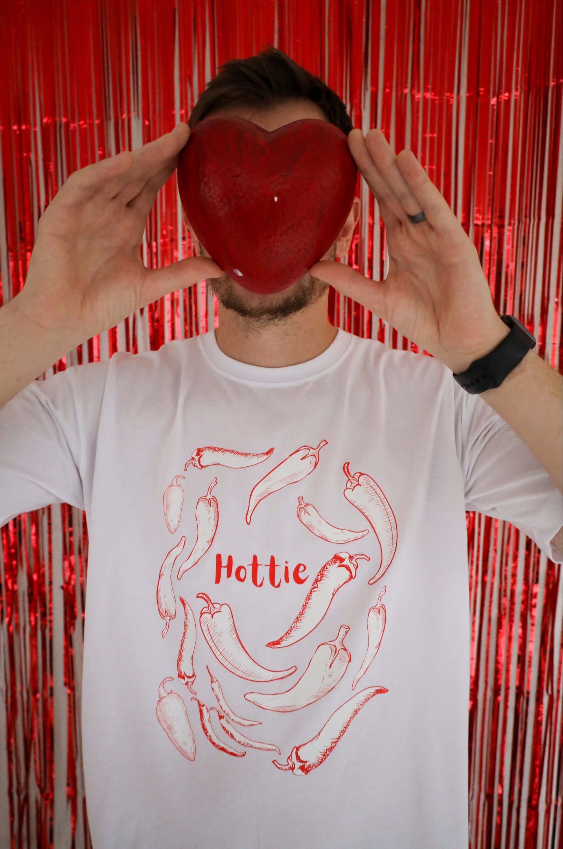 White graphic t-shirt with chilli design and Hottie text, funny cotton tee in bold red lifestyle setting South Africa