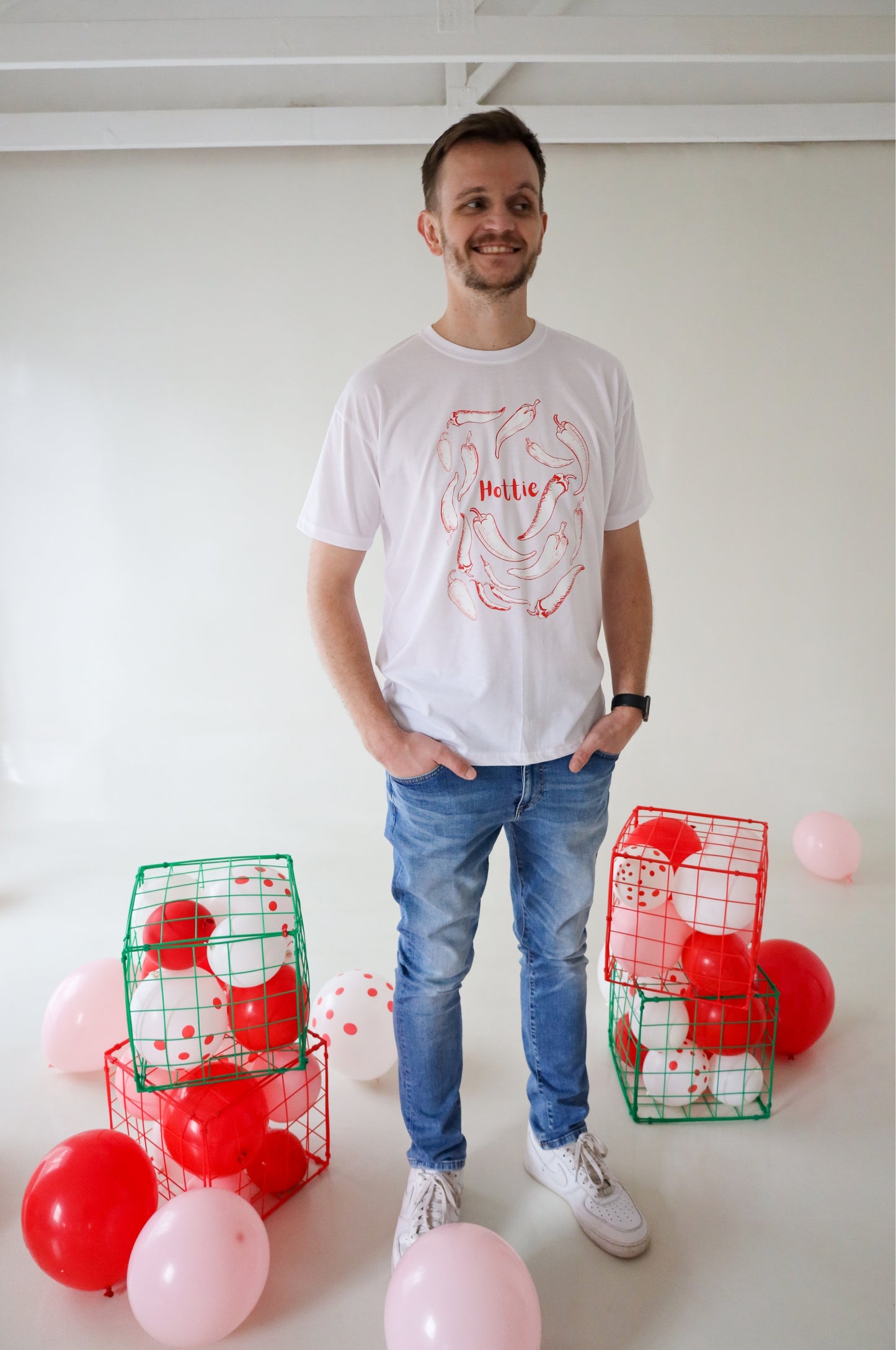 White graphic t-shirt with chilli design and Hottie text, funny cotton tee in bold red lifestyle setting South Africa