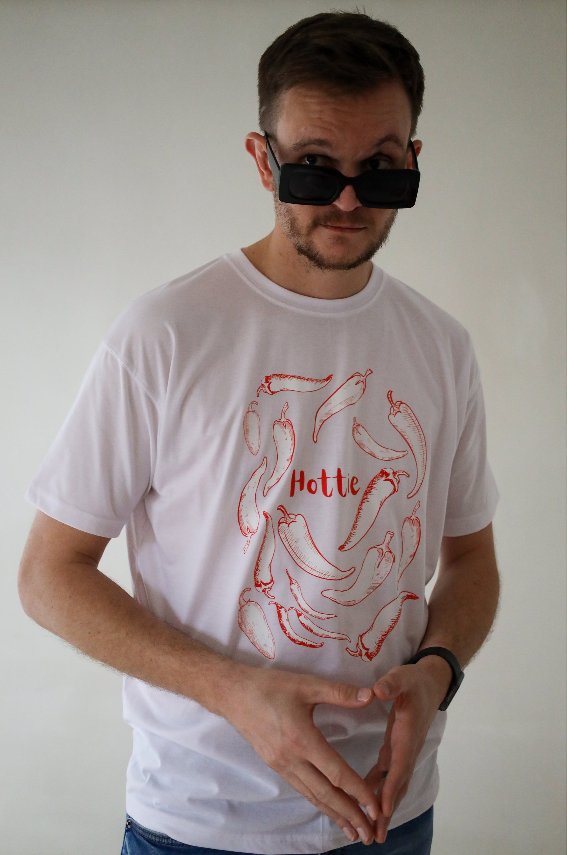 Man wearing white graphic t-shirt with chilli print and Hottie text, 100% cotton funny tee South Africa