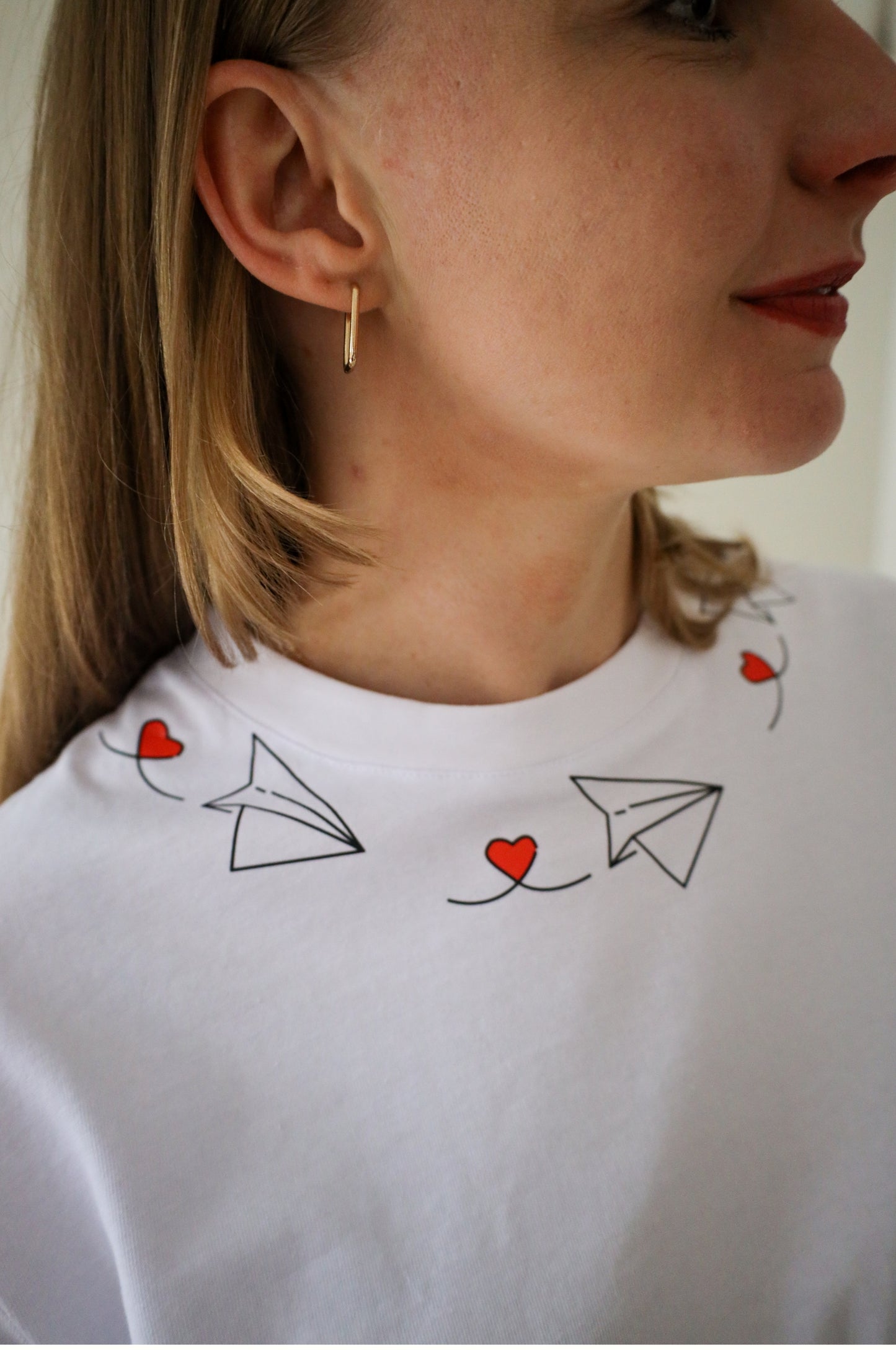Close-up of paper plane heart design on white cotton graphic t-shirt, quirky embroidered tee South Africa