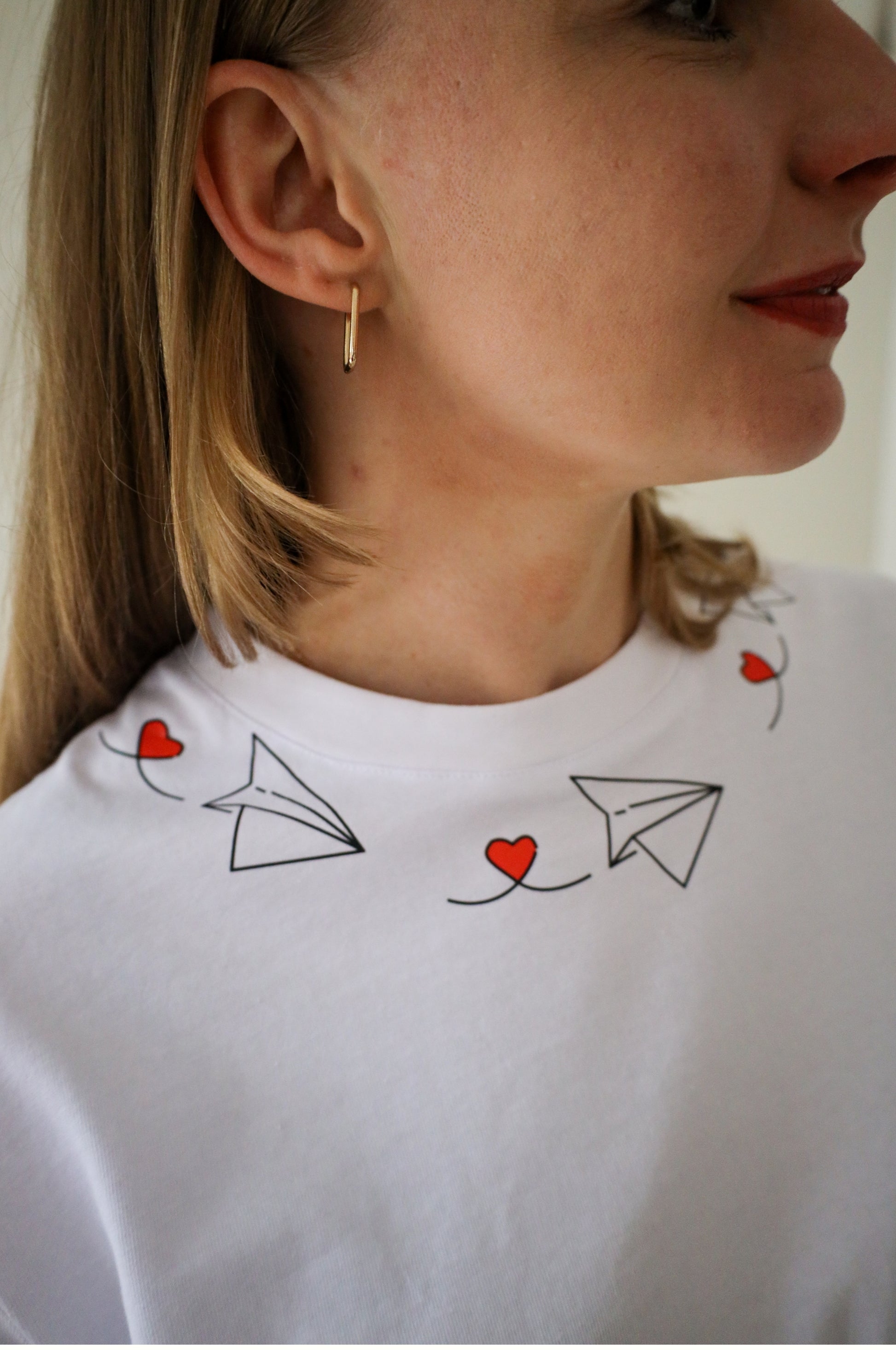 Close-up of paper plane heart design on white cotton graphic t-shirt, quirky embroidered tee South Africa